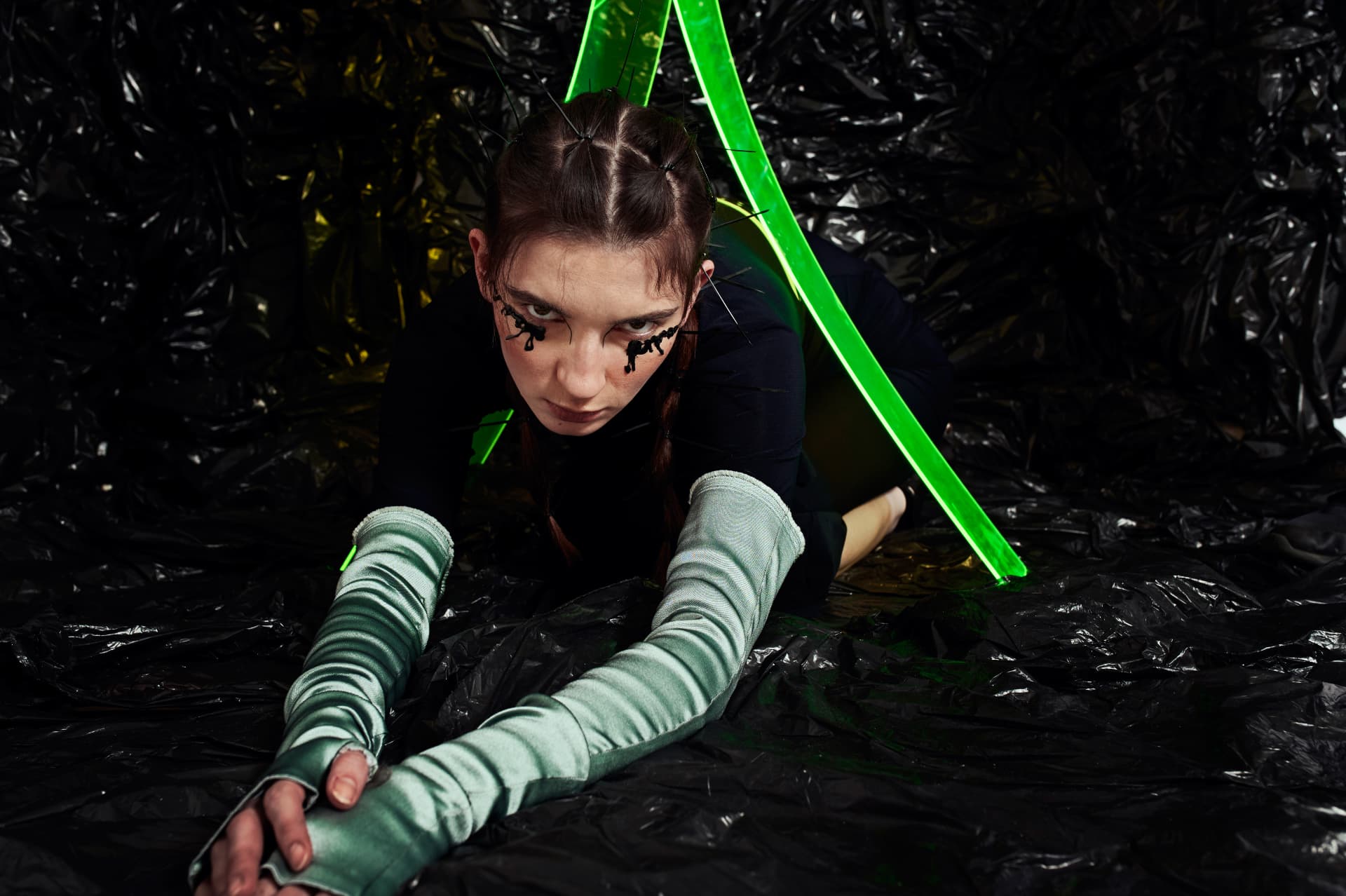 Low crawl across black plastic, acid green blade cutting the frame